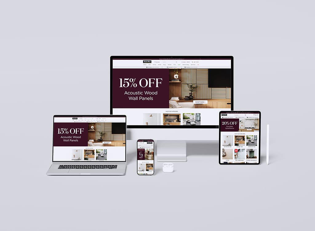 Display of various devices including a desktop, laptop, tablet, and smartphone showcasing a website offering discounts on acoustic wood wall panels. The promotional banners highlight 15% and 20% off sales, emphasizing home decor and soundproofing solutions.